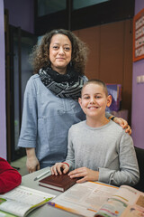 Female teacher with elementary student at language school class