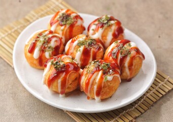 Takoyaki is a typical Japanese snack in the form of small balls made from wheat flour dough and filled with pieces of octopus.