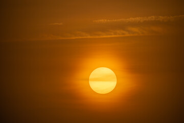 Dramatic sun silhouette during sunset in Shimen, Taiwan, casting warm light over tranquil seas.