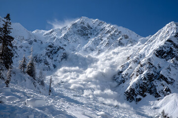 Fototapeta premium Majestic avalanche cascading down snowy mountain slopes