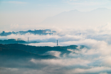 Ethereal morning view of misty mountains in Shilin New Taipei Taiwan, with a faint Taipei City...