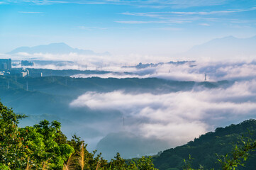 Rolling morning fog and clouds envelop the mountains of Shulin District New Taipei City Taiwan,...