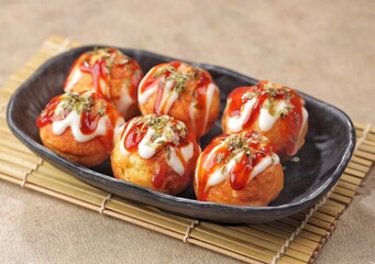 Takoyaki is a typical Japanese snack in the form of small balls made from wheat flour dough and filled with pieces of octopus.