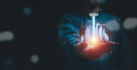 Businessman holding glowing virtual technical graph and chart for analysis stock market in 2026, technology investment and value investment concept.