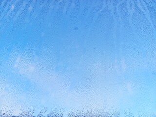 Dew drops on glass with blue sky background