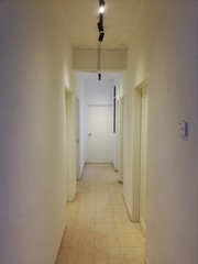 Apartment renovation interior showing wall repainting, lighting setup, furniture arrangement, and bathroom upgrade in clean modern living space