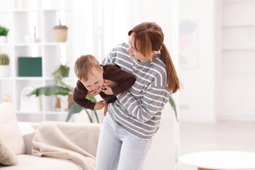 Happy mother playing with her son at home