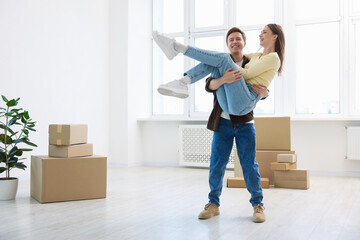 Happy young couple dancing and cardboard boxes at home. Moving day
