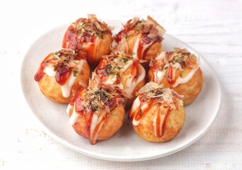 Takoyaki is a typical Japanese snack in the form of small balls made from wheat flour dough and filled with pieces of octopus.