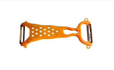 A vegetable peeler, a piece of kitchen utensils for peeling vegetables and fruits. Orange plastic...