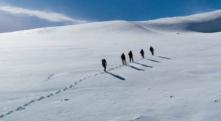 Mountaineering team and footprints walking on snowy mountain peaks