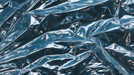 Close-up view of crumpled, glossy, dark-blue plastic sheeting.