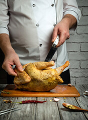 In a rustic kitchen, a chef skillfully carves a beautifully seasoned chicken on a wooden cutting...
