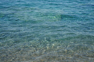 Tranquil Clear Water with Visible Stones at Shoreline