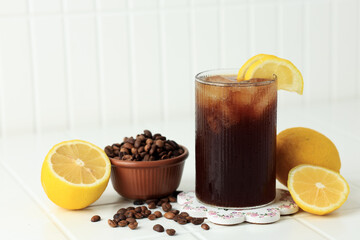 Coffee with Tonic in a Tall Glass with Ice and Lemon on White Table Background. T
