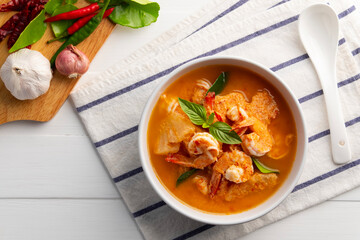 Red curry Pineapple and shrimp in white bowl.(Kang Kua Subpharod Kung) Thai food.Top view.