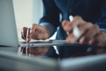 Closeup, business woman working on laptop computer and using digital tablet at home office. Feelancer working online job via tablet and laptop, business background, internet technology