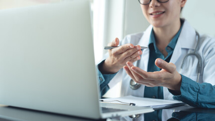 Doctor using laptop computer online video call, telemedicine to patient, prescribe medicine. Tele...