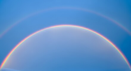 Fototapeta premium Vibrant Rainbow Arcs Across a Serene Blue Sky Atmospheric Optics Phenomenon.