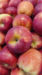 Close up pile of tasty fresh apples sold at the market as a background.