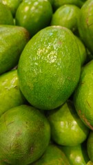 Close up pile of tasty fresh avocados sold at the market as a background.