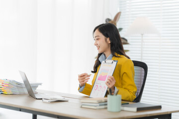 Business Presentation: A woman at desk with a laptop, presenting financial data in a modern office...