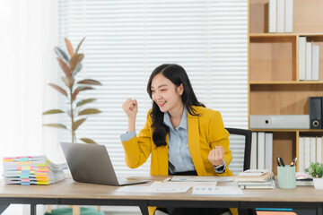 Successful Woman in Office: A dynamic professional, radiating accomplishment and joy, raises her...