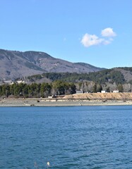 Fototapeta premium Serene lakeside scene with mountains and clear blue sky