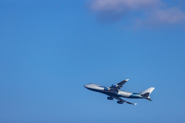 Boeing 747 cargo airplane climbing in the blue sky near Vijfhuizen, Netherlands