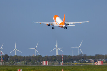 Fototapeta premium EasyJet Airbus A320 taking off from Amsterdam Airport Schiphol with wind turbines in background