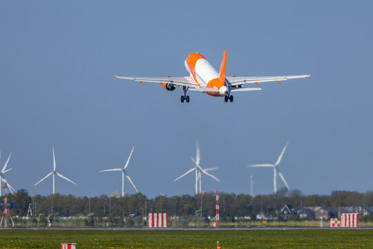EasyJet Airbus A320 taking off from Amsterdam Airport Schiphol with wind turbines in background