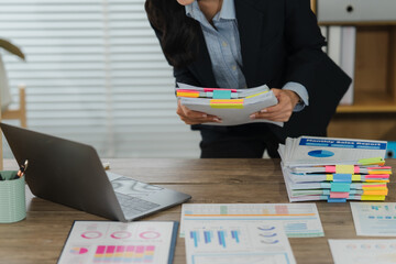 Busy Business: A focused individual, immersed in an office environment, reviews important documents...
