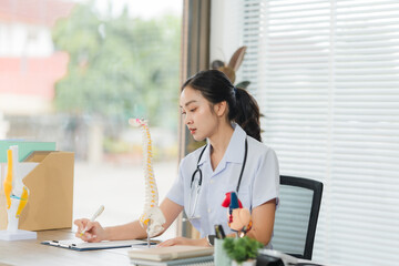 Focused Physician in Study: A dedicated physician, engrossed in studying medical literature at her...