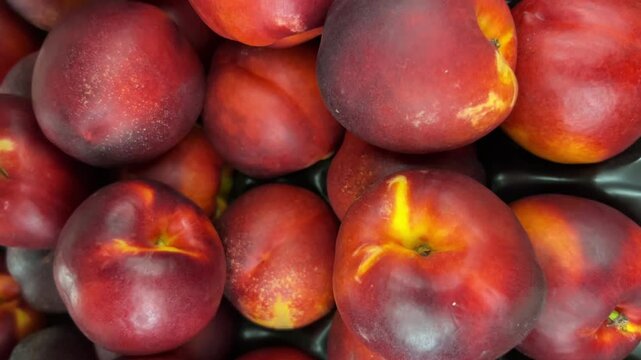 Tracking shot in close up on nectarine peaches on the greengrocery counter