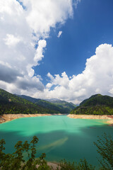 Sauris Lake reflecting clouds in turquoise water, Udine, Italy