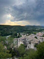 Obraz premium Scenic view of a historic village surrounded by lush greenery and dramatic skies in the evening