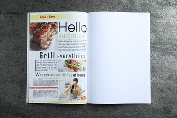 Open magazine on grey table, top view. Mockup for design
