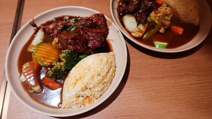 close up of Japanese Pork Cartilage curry with rice, served with vegetables, including broccoli, carrots, and zucchini on a wooden table