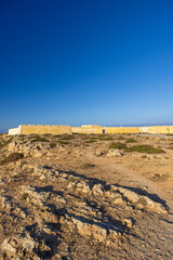 Fortaleza de Sagres dominating the rocky landscape under a clear blue sky in Vila do Bispo, Portugal