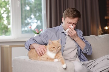 Man suffering from allergy with his cat on sofa at home