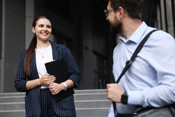 Happy coworkers discussing something near office building
