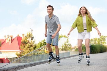 Happy couple roller skating together on street