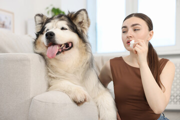 Woman suffering from allergy with her dog at home