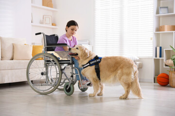 Girl in wheelchair with her service dog at home