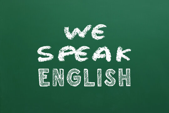 We Speak English inscription on green chalkboard. Language course