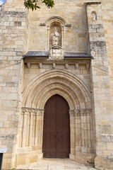 Fototapeta premium Saint Pierre abbey church entrance showing statue and coat of arms in La Sauve, France