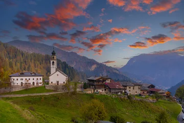 Gordijnen Alpen Sauris di Sopra glowing under colorful clouds at sunrise in Friuli, Italy  © Richard Semik