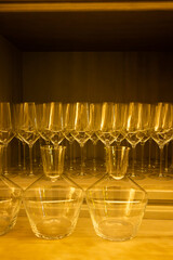 Elegant wine glasses and decanters filling wooden cupboard shelf
