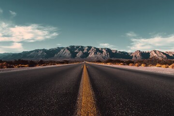 Naklejka premium Open Road Ahead A Journey Through Majestic Mountains Under a Clear Sky