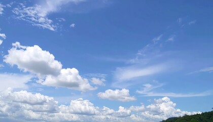 Vast blue sky with fluffy, billowing white clouds scattered